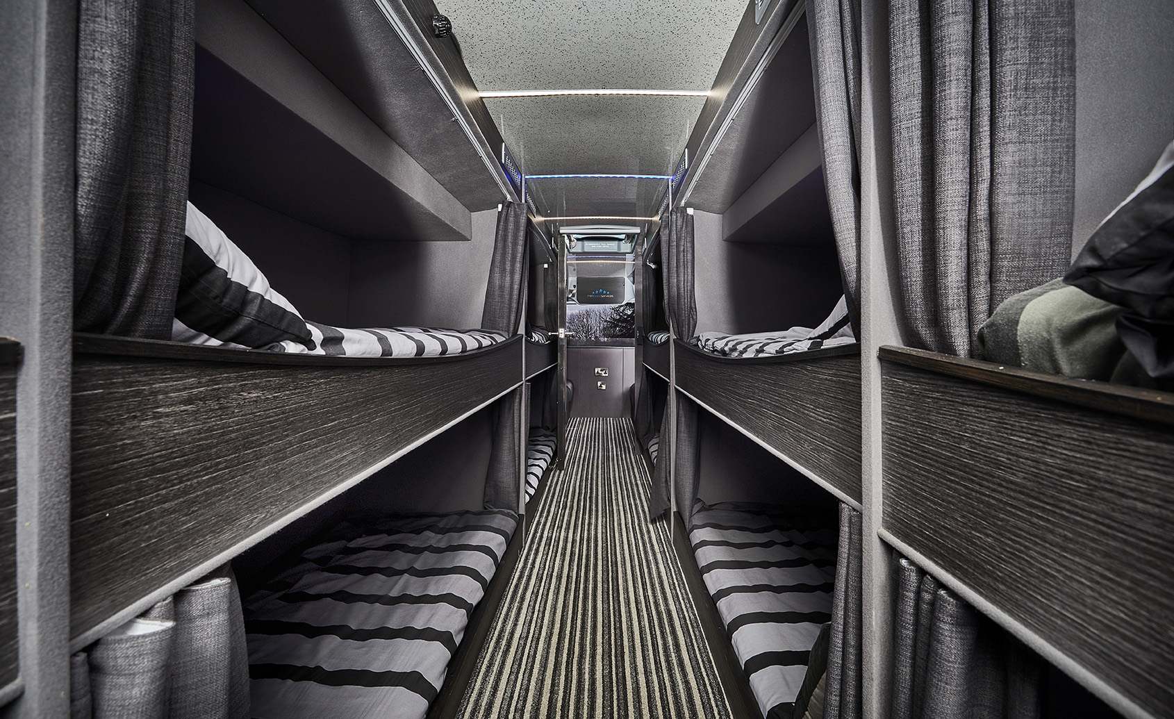 Onboard our sleeper buses. Inside view of the individual bunks we offer, with duvets and curtains.